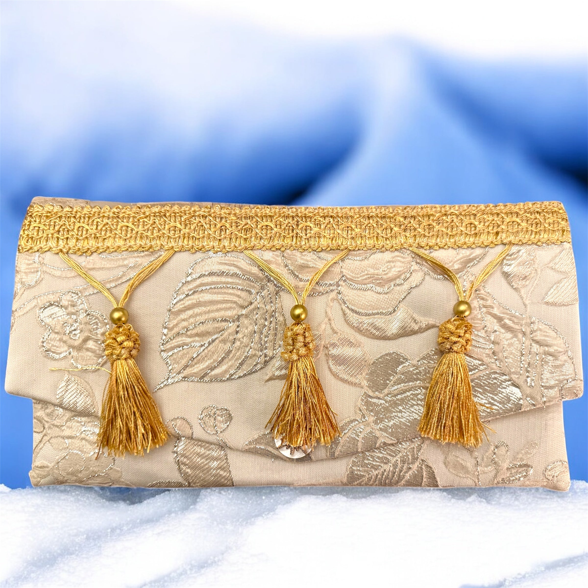 Pochette matelassé in seta dorata con frangia oro